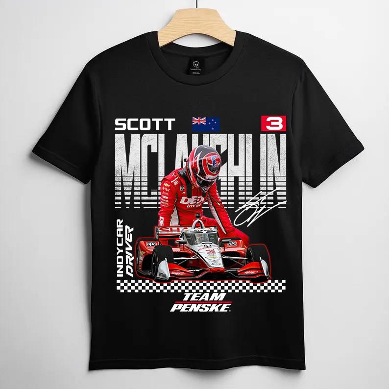 May include: Black t-shirt featuring a graphic of a race car and driver in a red racing suit and helmet. The shirt includes the name "SCOTT McLAUGHLIN" and the text "INDYCAR DRIVER" and "TEAM PENSKE".