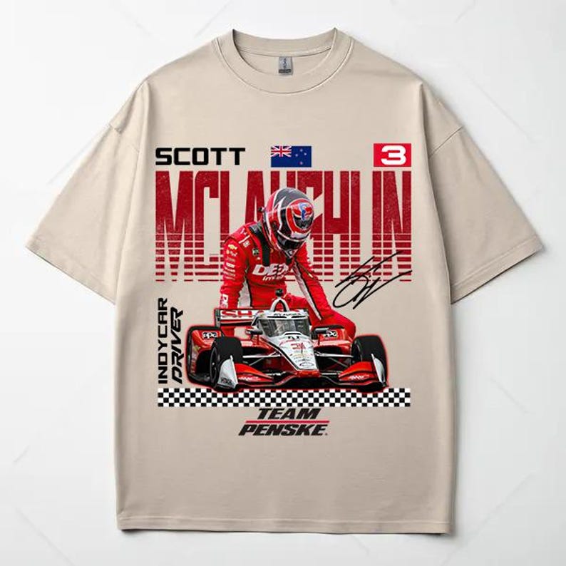 May include: Beige t-shirt featuring a graphic of an IndyCar driver in a red racing suit and helmet, with a red and white race car. The shirt includes the text "SCOTT MCLAUGHLIN" and "TEAM PENSKE".