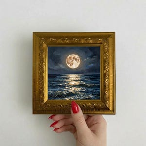 Puede incluir: Una pintura al óleo cuadrada de una luna llena sobre un océano oscuro y texturizado por la noche, con pinceladas visibles y un reflejo brillante en el agua, dentro de un marco dorado ornamentado con detalles en relieve.
