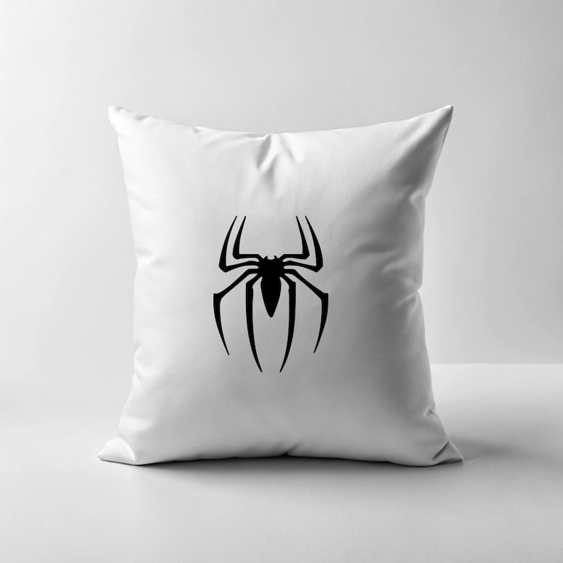 May include: White square throw pillow featuring a large black spider emblem. The spider design is centered on the pillow and has eight legs. The pillow is made of a soft, smooth fabric.