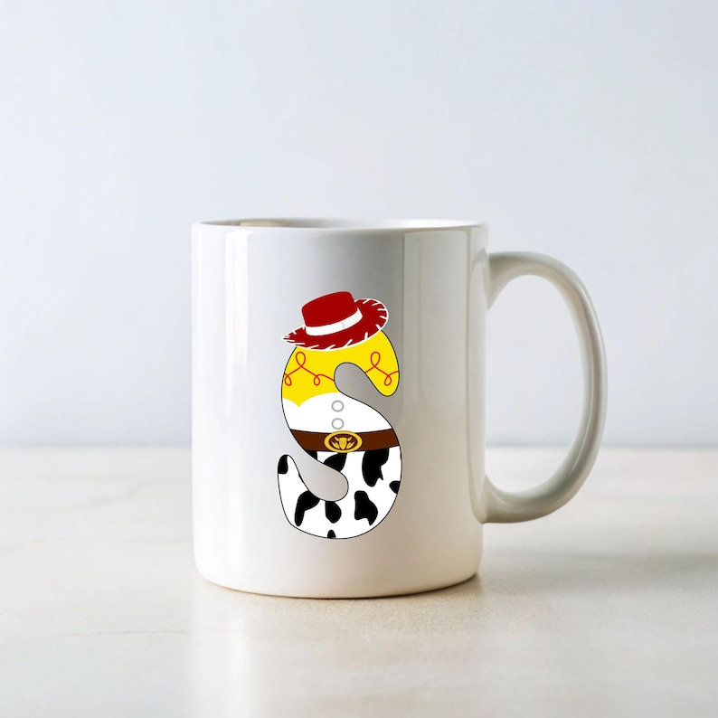 Peut inclure: Mug en c&eacute;ramique blanche avec la lettre "S" d&eacute;cor&eacute;e sur le th&egrave;me du cowboy. La lettre pr&eacute;sente un chapeau rouge, une chemise jaune, une ceinture marron et un motif de vache, pour un style amusant et cartoon.