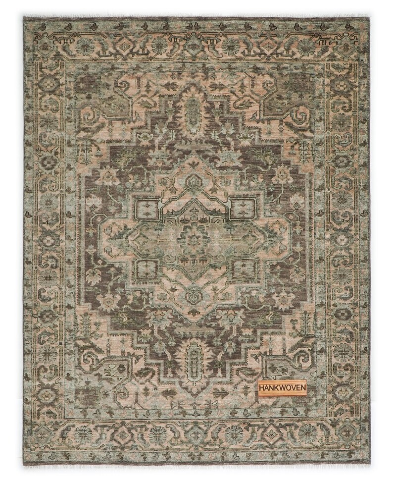 May include: Rectangular area rug with an intricate, distressed pattern in shades of brown, beige, and teal. The rug features a central medallion design and a detailed border. The tag in the corner reads "HANKWOVEN".