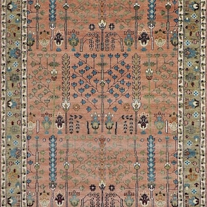 Pode incluir: Um tapete retangular com um desenho central de árvores estilizadas e motivos florais em tons de coral, azul e verde. O tapete tem uma borda detalhada com padrões repetidos. O design é simétrico e tradicional.