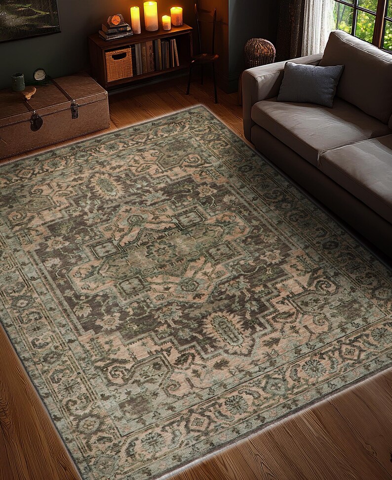May include: An area rug with an intricate, traditional design in shades of brown, green, and beige. The rug features a detailed pattern with a border, placed on a hardwood floor. The rug is rectangular and covers a large area of the room.