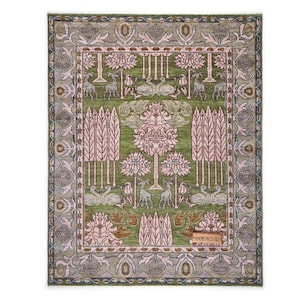 以下が含まれることがあります： 手織りの長方形ラグ。中央は緑色で、ピンク色の木と鹿のモチーフが描かれています。縁はくすんだグレーで、花柄と幾何学模様があります。伝統的で装飾的なデザインです。