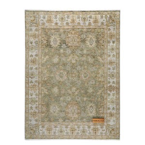 May include: Rectangular area rug with a central sage green field and an ornate border in cream and tan. The rug features a detailed floral pattern and a rectangular label that reads "HANKWOVEN".