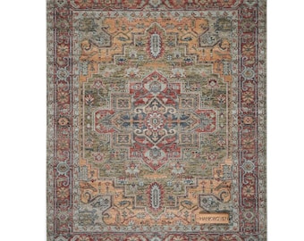 May include: Rectangular rug with a traditional, distressed design. The rug features a central medallion in shades of red, blue, and gold, surrounded by a border in similar tones. The rug has a faded, vintage look, with the text "HANKWOVEN" on a small tag.