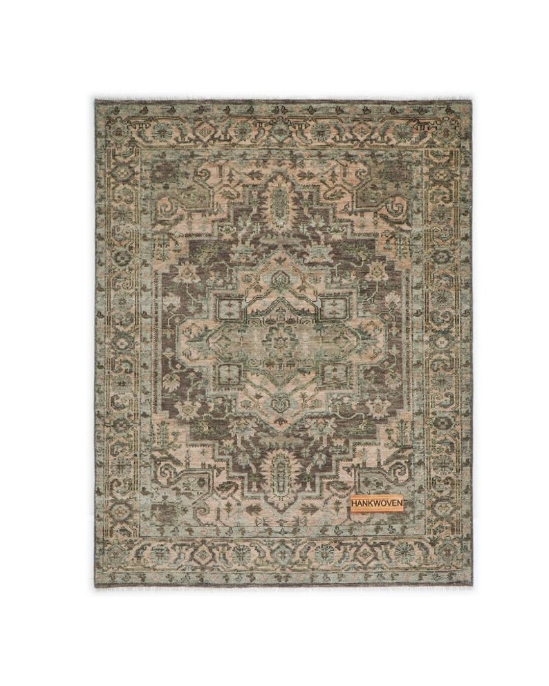 May include: Rectangular area rug with an intricate, distressed pattern in shades of brown, beige, and green. The rug features a central medallion design and a detailed border. The tag in the image reads "HANKWOVEN".