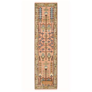 Puede incluir: Una alfombra rectangular tejida a mano con un campo central de color melocotón. La alfombra presenta un patrón floral repetido en azul, verde y crema, con un borde verde y crema. El texto "HANKWOVEN" es visible en la parte inferior. La alfombra mide unos 60 cm de ancho.