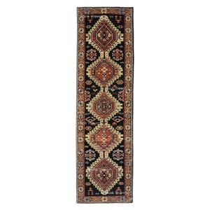 May include: A long, rectangular rug with a black background and a repeating geometric pattern in shades of red, beige, and brown. The rug features diamond and floral motifs, creating a traditional, decorative design. The rug is suitable for a hallway or entryway.
