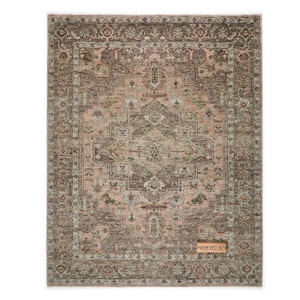 Puede incluir: Una alfombra rectangular con un diseño tradicional intrincado. La alfombra presenta un medallón central en tonos de rosa, marrón y verde, rodeado por un borde detallado. La alfombra tiene un aspecto envejecido y vintage. La etiqueta dice "HANKWOVEN".