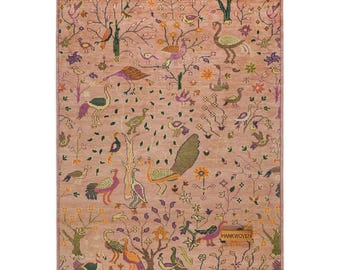 May include: A rectangular, hand-woven rug with a detailed pattern of birds, trees, and flowers in shades of pink, green, orange, and purple. The rug has a fringe border and a label that reads "HANKWOVEN".
