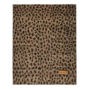 May include: Rectangular area rug with a brown background and dark green spots. The rug has a textured appearance and a small rectangular tag in the bottom right corner that reads "HANKWOVEN".