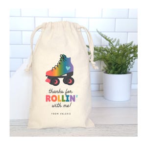May include: A white cotton drawstring bag with a rainbow roller skate design and the text "thanks for rollin' with me! from Valerie".