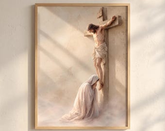 May include: A framed wall art print depicting a figure with long hair and a loincloth nailed to a wooden cross. Below the cross, a person draped in a long, flowing white robe kneels with hands clasped in a gesture of prayer or mourning.