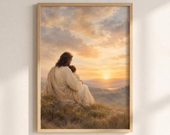 May include: A framed wall art print depicting a person with long hair wearing a light-colored robe, sitting on a grassy hill while holding a small child. They are looking out over a vast landscape at sunset with golden clouds and mountains.