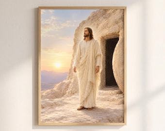 May include: A framed wall art print depicting a figure with long brown hair and a beard, wearing a cream-colored robe, standing outside a stone cave entrance at sunrise. The background features a rocky landscape and a soft, glowing sun.