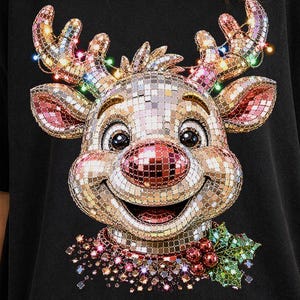 May include: A black t-shirt featuring a large graphic of a reindeer head made of reflective disco ball tiles. The reindeer has a red nose, antlers adorned with colorful string lights, and a small cluster of green holly leaves and red berries below.