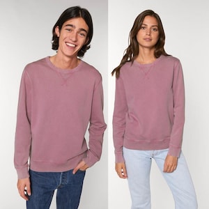Puede incluir: Dos personas con sudaderas color malva a juego con cuello redondo. Las sudaderas tienen mangas largas y un dise&ntilde;o cl&aacute;sico. La persona de la izquierda lleva vaqueros azules. La persona de la derecha lleva vaqueros azul claro. Las sudaderas tienen un cuello cosido.