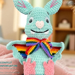May include: A crocheted plush bat toy in shades of teal, with large ears and a heart-shaped nose. It has a rainbow-colored bow and pink feet. The text "Bella the bat CROCHET PATTERN" is at the top.