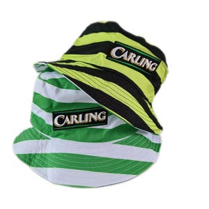 May include: Two green and white striped bucket hats with black stripes. The hats have a black patch with the word "Carling" embroidered in white.