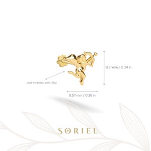 May include: A gold-coloured earring featuring a Cupid design with a bow and arrow. The earring measures 9.57 mm wide and 8.51 mm high. The post thickness is 1mm (18g). The brand name "SORIEL" is at the bottom.