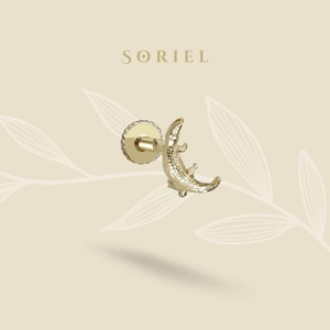 May include: A gold-toned earring with an alligator motif. The earring has a post fitting and is set against a neutral background. The brand name "SORIEL" is displayed at the top.