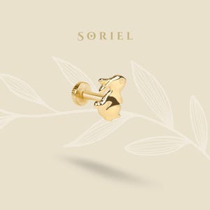 May include: A gold-colored stud earring featuring a small, detailed bunny design. The earring has a flat, circular backing and a post for insertion. The brand name "SORIEL" is displayed above the earring.