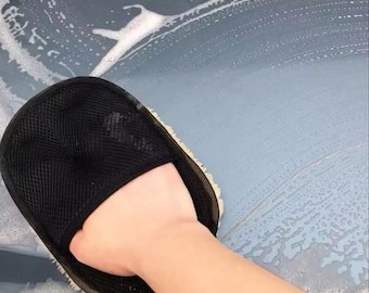May include: A black microfiber car wash mitt with a white, fluffy, microfiber pad attached to the back. The mitt is being used to wash a car.