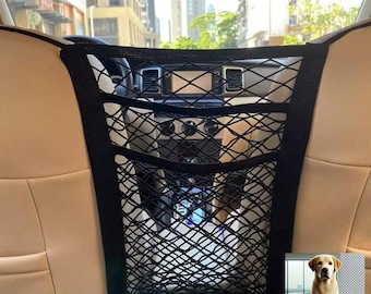 May include: Black mesh cargo net for the backseat of a car. The net has multiple compartments and is secured to the headrests. A golden retriever dog is pictured in the bottom right corner.