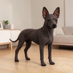 Puede incluir: Una figura de perro de ganchillo de color marrón oscuro de pie en perfil. La escultura textil hecha a mano presenta una superficie de hilo texturizado, orejas puntiagudas con detalles internos en marrón claro, ojos oscuros y una cola fina.