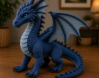 May include: A crocheted dragon figurine in shades of deep blue and light blue. The creature features textured scales, large wings with a light blue interior, a long curved tail with spikes, and sharp black claws on its four feet and light blue eyes.