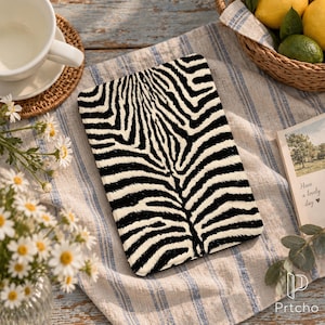 May include: A rectangular electronic reader cover featuring a high-contrast black and white zebra stripe pattern. The cover has a smooth, flat surface with a symmetrical design that mimics the natural markings of a zebra's coat.