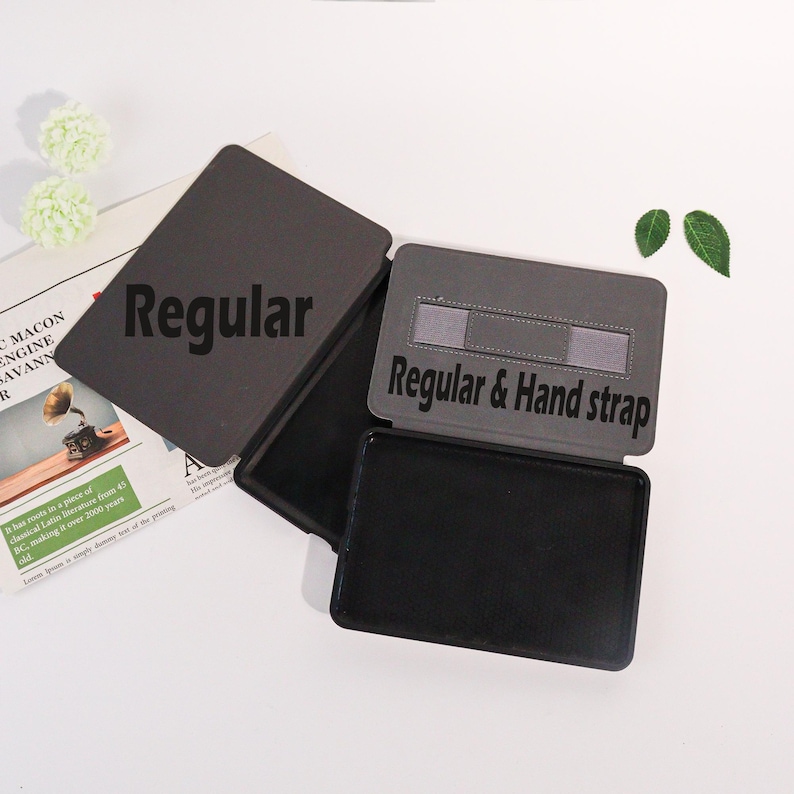 May include: A set of dark gray tablet cases with the word "Regular" printed on the top cover. One case is open, revealing a black interior and a hand strap. The text "Regular & Hand strap" is printed on the open case.