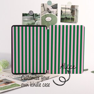 May include: A Kindle case with a vertical striped pattern in green and pink. The case is black-edged and features the name "Alice" in cursive. The text "Customize your own kindle case" is also visible.