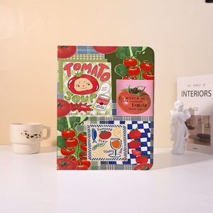 Könnte beinhalten: Ein rechteckiger Notizbuchumschlag mit einer Collage aus tomatenbezogenen Illustrationen, darunter rote Tomaten an Reben, ein "Tomato Soup"-Etikett sowie der Text "Eu NUNCA na vida comerei tomate" und "SUMMER DIET STARTS NOW" mit verschiedenen Lebensmittelsymbolen.