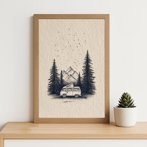 May include: A framed black and white illustration of a camper van in a forest scene with mountains. The artwork shows two tall pine trees, a starry sky, and a small succulent in a white pot. The frame is made of wood.