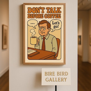 May include: A framed print with the text "DON'T TALK BEFORE COFFEE" above an illustration of a man holding a coffee mug. The man is at a desk with a speech bubble that says "Let's go!" and another with three dots. The frame is light brown.