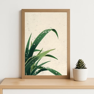 May include: A framed print featuring green blades of grass with water droplets. The artwork has a light beige background and is set in a natural wood frame. A small potted succulent is on the wooden surface below.