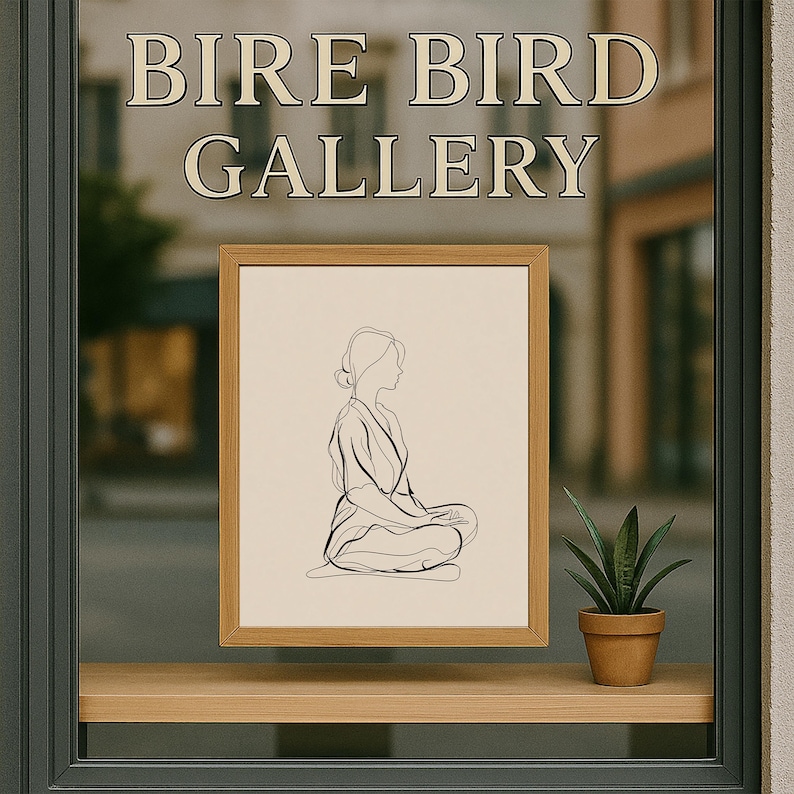 May include: A framed line art print of a seated figure in a wooden frame. The artwork is displayed in a window with the text "BIRE BIRD GALLERY" above. A small potted plant sits on a wooden shelf below the artwork.