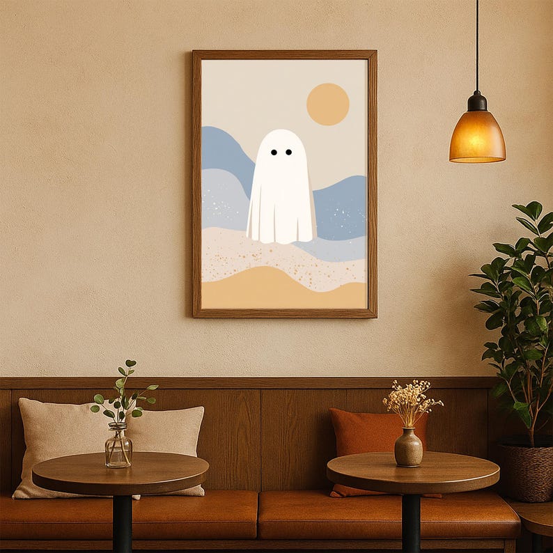 May include: A framed art print with a minimalist ghost illustration. The white ghost with two black dots for eyes is set against a backdrop of blue and yellow abstract landscape with a yellow sun.