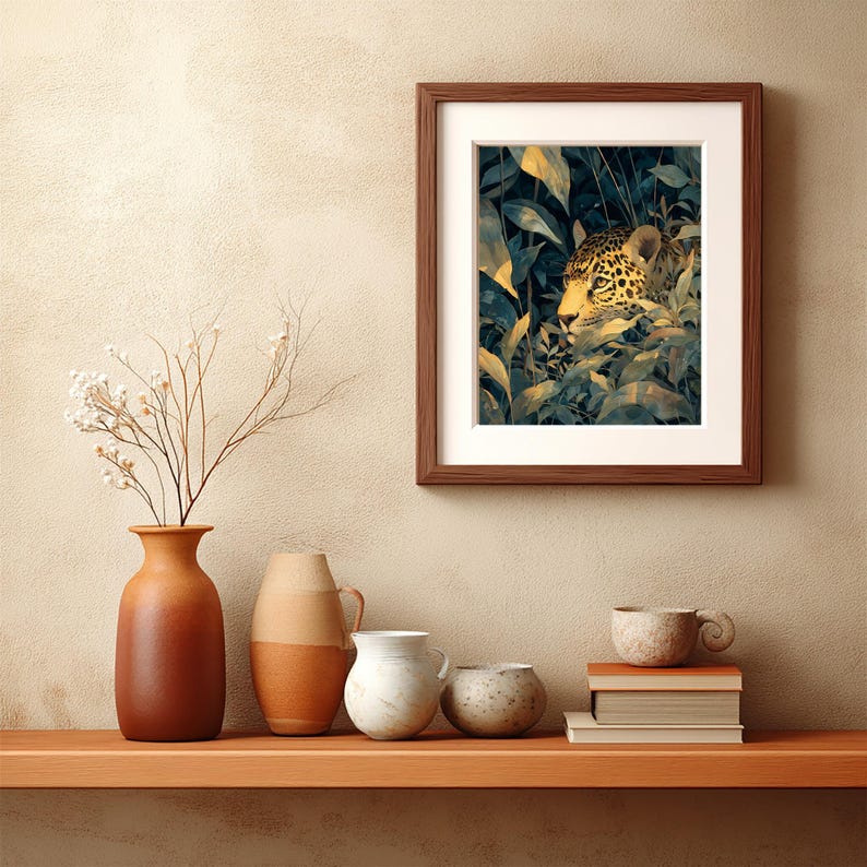 May include: A framed art print featuring a jaguar peering through lush green and yellow foliage. The artwork is set in a dark brown wooden frame with a white mat. The print is displayed on a wooden shelf with decorative vases and books.