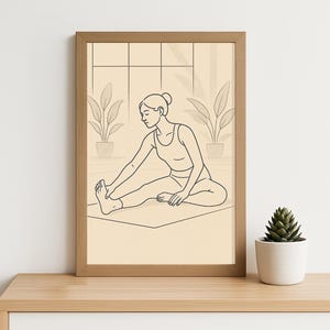 May include: A framed line art print showing a person in a yoga pose, touching their foot. The artwork uses black lines on a beige background, with a wooden frame. The scene includes potted plants and a window, creating a calm atmosphere.