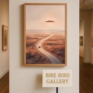 Puede incluir: Obra de arte enmarcada que representa un paisaje desértico con una carretera sinuosa y un coche. Un objeto volador no identificado flota en el cielo. La obra de arte se exhibe en una pared beige. El letrero de abajo dice "BIRE BIRD GALLERY."