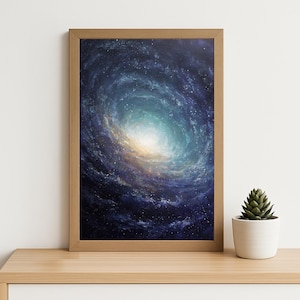 May include: A framed print of a galaxy with a swirling pattern of blues, whites, and yellows. The artwork is displayed in a light brown wooden frame and rests on a wooden surface. A small potted succulent is to the right of the frame.