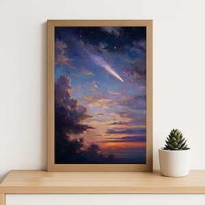 May include: A framed art print of a celestial scene. The artwork features a vibrant sunset with a comet streaking across a sky filled with clouds. The colour palette includes shades of blue, orange, and purple. A small succulent in a white pot sits on a wooden surface.