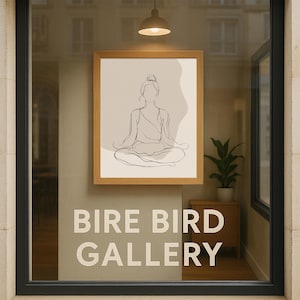 May include: A window display with a framed artwork showing a line drawing of a person in a yoga pose. The text "BIRE BIRD GALLERY" is displayed in white lettering. A small plant and a light fixture are also visible in the shop window.