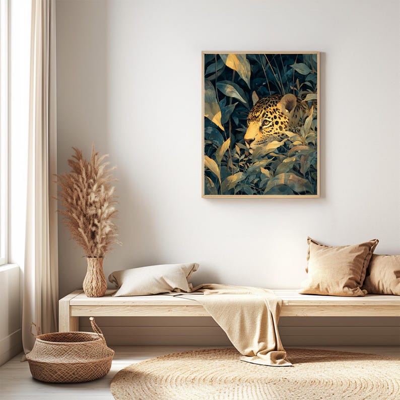May include: A framed art print featuring a jaguar peering through lush green and yellow foliage. The artwork has a natural, jungle theme, with the big cat's spotted coat and face visible. The print is displayed in a light-colored wooden frame.