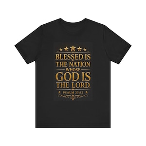 Pode incluir: Camiseta preta com um gráfico dourado que diz: "Bem-aventurada é a nação cujo Deus é o Senhor." O design inclui estrelas douradas e elementos decorativos, com a referência bíblica "Salmo 33:12".