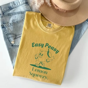 May include: A yellow t-shirt with a green cartoon lemon character and the text "Easy Peasy Lemon Squeezy."